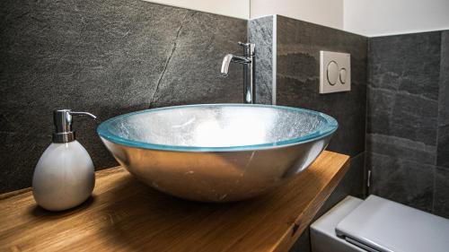 a bathroom with a large bowl sink on a wooden counter at Lorent House in Merano