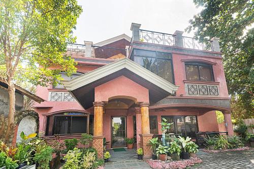 Casa grande de color rosa con balcón en RedDoorz at Coco Grove Tourist Inn en Panglao City