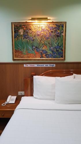 a bedroom with a bed and a painting on the wall at Phadaeng Hotel in Ubon Ratchathani