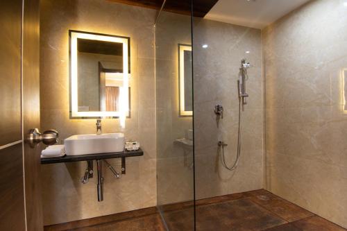 y baño con lavabo y ducha. en The Liverpool Hotels Marathahalli, Outer Ring Road, en Bangalore
