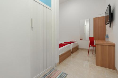 a bedroom with a bed and a desk and a chair at RedDoorz @ Graha Cemerlang Maros in Makassar