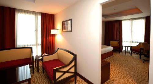 a hotel room with a bed and a chair at Holiday Inn Olaya by IHG in Riyadh