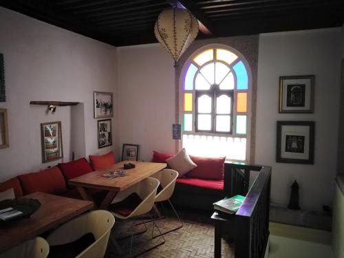 uma sala de estar com um sofá, uma mesa e uma janela em Dar El Paco em Essaouira