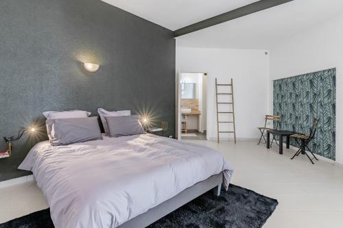 une chambre avec un grand lit blanc et un bureau dans l'établissement Le Saint Clair par Dodo-a-Cassis, à Cassis