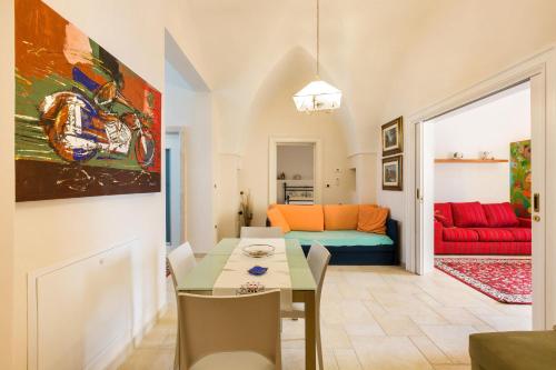a living room with a table and a red couch at Dimora Maria Luisa by BarbarHouse in Merine
