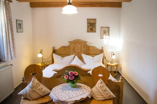 a bedroom with a bed and a table with a vase of flowers at Hotel Gerberhaus in Rothenburg ob der Tauber