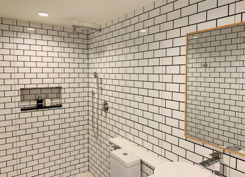 卡隆沙灘的住宿－阿克圖爾賓館，白色瓷砖浴室设有卫生间和镜子