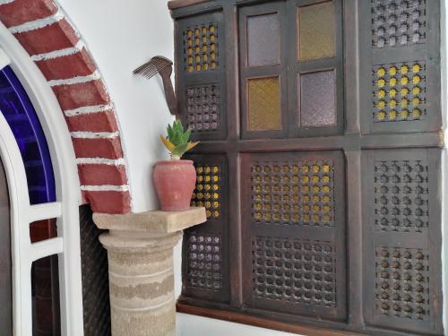 a wooden door with a vase on a pillar at Dar El Paco in Essaouira