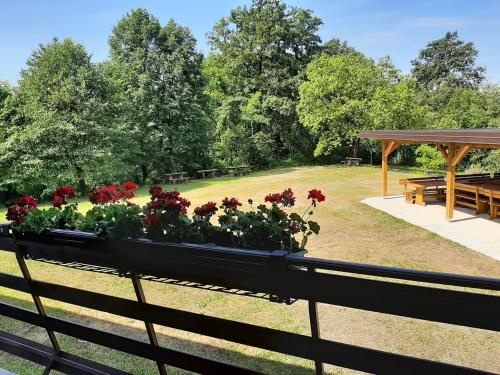 a garden with a bench with flowers on it at Koča sredi gozda in Kanal