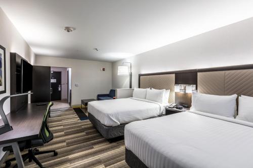 a hotel room with two beds and a desk at Holiday Inn Express & Suites Jersey City North - Hoboken by IHG in Jersey City