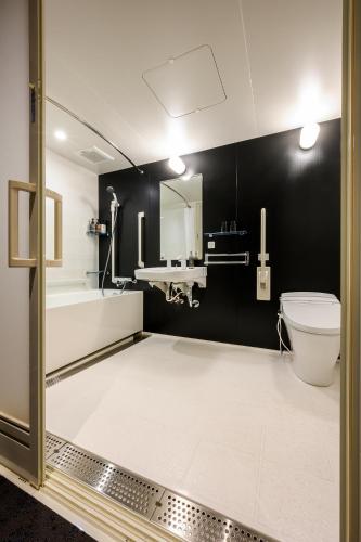 a bathroom with a toilet and a sink and a tub at HOTEL WOOD TAKAYAMA in Takayama