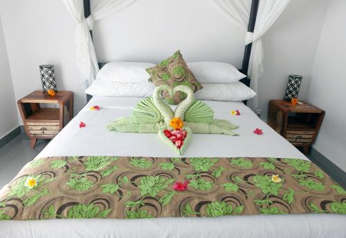 a bed with two swans made out of hearts at Villa Paradise Lovina in Temukus