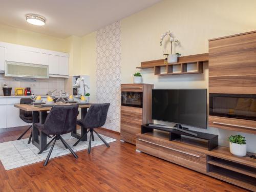 a living room with a table and a flat screen tv at Alpe Adria Apartments - Top 1 by S4Y in Faak am See