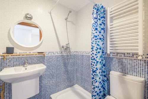 a bathroom with a sink and a toilet and a mirror at Balea 5 - Local Rentss in Orio