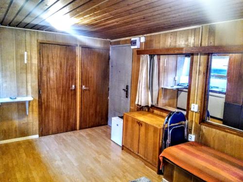 una habitación con suelo de madera y una habitación con banco en Two Rooms Rustic House - Self Check-In, en Bucarest