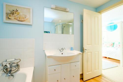 ein Badezimmer mit Waschbecken und Spiegel in der Unterkunft Shell Cottage in Aldeburgh