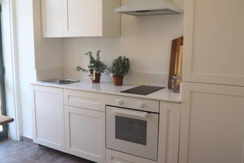 una cucina bianca con mobili bianchi e un lavandino di STUDIO in the CITY a La Valletta