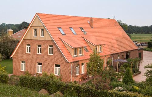 una gran casa de ladrillo con techo naranja en Gästeapartment auf einem Bauernhof en Bad Bentheim