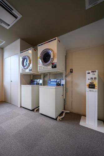 a laundry room with a washer and a washing machine at HOTEL WOOD TAKAYAMA in Takayama