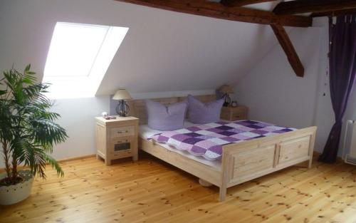 een slaapkamer met een bed met paarse kussens en een raam bij Auszeit-Landleben Domizil in Sallgast