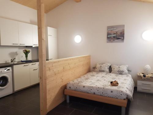 a small bedroom with a bed and a kitchen at L'ANGOLO DEI SAPORI in Rueun
