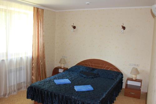 a bedroom with a bed with two blue pillows on it at Вілія in Lomacineţi