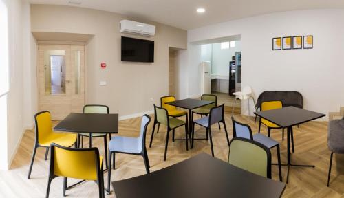uma sala de jantar com mesas e cadeiras amarelas em Casa Vargas Figueroa restaurante Casa del Sol em Cáceres