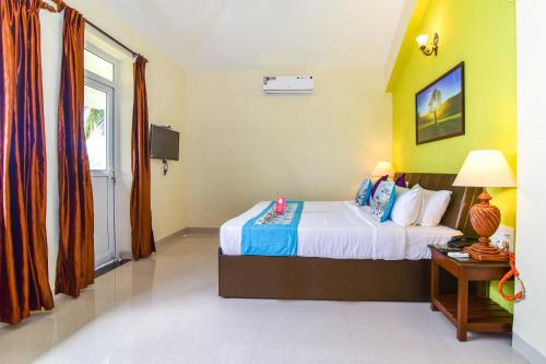 a hotel room with a bed and a window at Meadow View Resort in Majorda