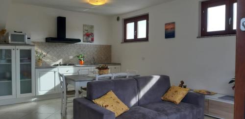 a living room with a couch and a table in a kitchen at Villa Rosa in SantʼAntìoco