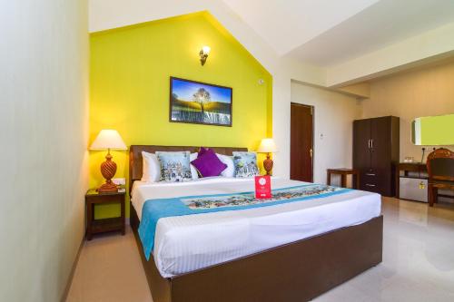 a bedroom with a large bed and a yellow wall at Meadow View Resort in Majorda