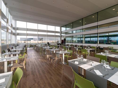 a restaurant with tables and chairs and large windows at Hotel Las Terrazas in Burgos