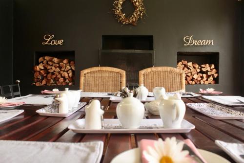 a table with chairs and plates and a table with fireplaces at Cathkin Cottage Bed & Breakfast in Champagne Valley