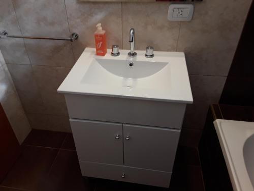 a bathroom with a white sink and a shower at Departamentos Solares - Bravard in Bahía Blanca