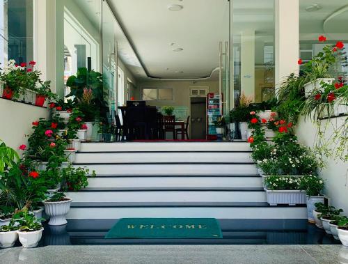 a welcome sign on the stairs of a building with flowers at Dalat Eco Hotel in Da Lat