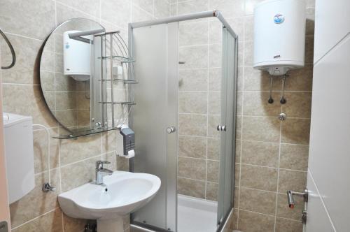 a bathroom with a sink and a shower at Garni Hotel Lotos in Niš