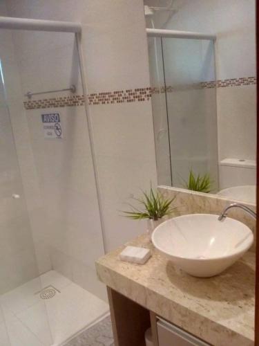 een badkamer met een wastafel en een douche bij Pousada do Maninho in Penha