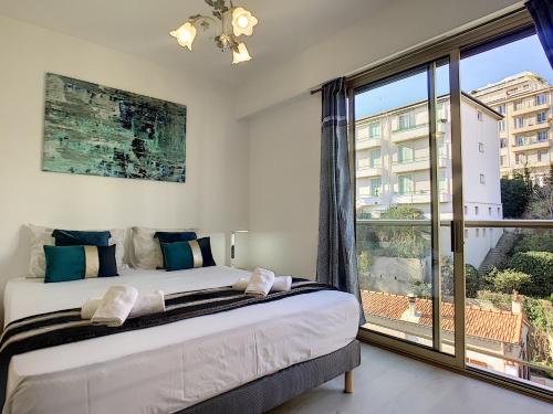 une chambre avec un lit et une grande fenêtre dans l'établissement Nestor&Jeeves - SUNSET TERRACE - Central - Free parking - Top floor, à Nice