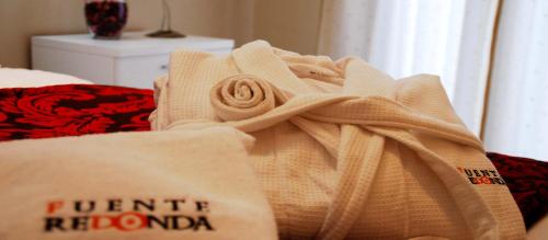 a towel sitting on a bed next to a bag at FUENTE REDONDA EN BAEZA in Baeza