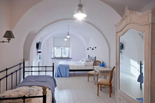 シュフィドニツァにあるバロコヴィ ザコンテクのベッドルーム1室(ベッド2台、テーブル、テーブル、シドックスシドックス付)