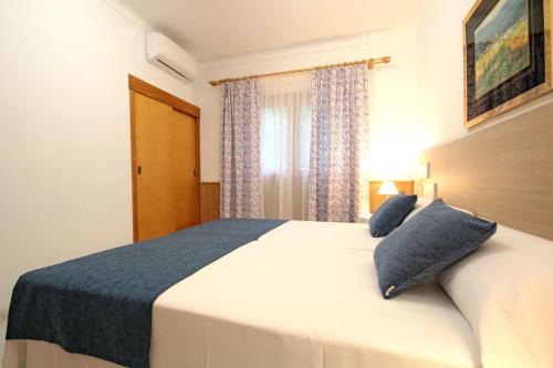 a bedroom with a large white bed with blue pillows at Villa Capllonch in Banyalbufar