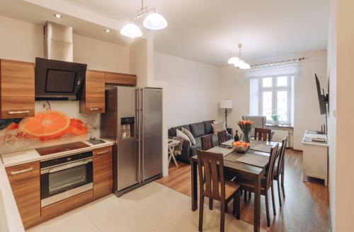 a kitchen and dining room with a table and a refrigerator at Apartament Rynek - Zielona Kamienica in Duszniki Zdrój
