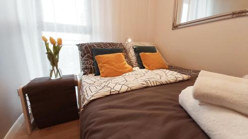 kanapę z poduszkami w pokoju w obiekcie Central Apartments Ogrody 1 & Parking w Gdańsku