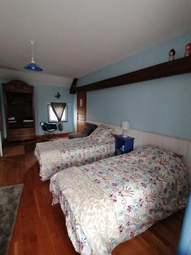 a bedroom with two beds and a couch at La Parisiere in Gavray