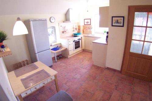 a kitchen with a refrigerator and a table in it at Dünenhof DÜNENHOF Whg. D-07 in Wustrow