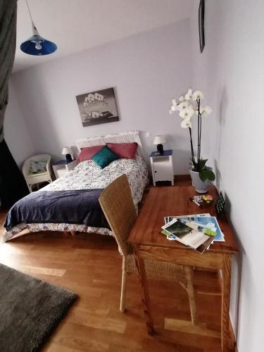 a bedroom with a bed and a wooden table with a table sidx sidx at La Parisiere in Gavray