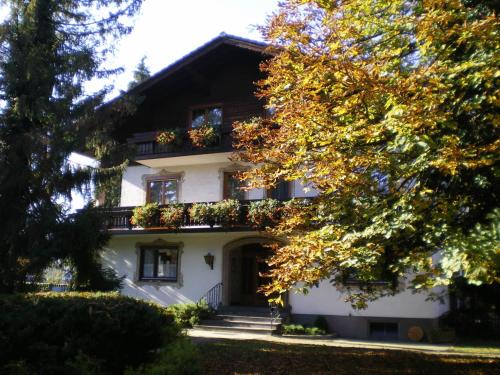 a large white house with flowers on the windows at Frühstückspension Helmhof in Salzburg