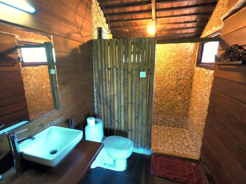 ein Bad mit einem Waschbecken, einer Dusche und einem WC in der Unterkunft Molyka Lodge in Banlung