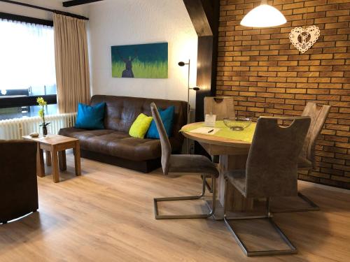 ein Wohnzimmer mit einem Tisch und einem Sofa in der Unterkunft Ferienanlage Vorauf - be happy in Siegsdorf