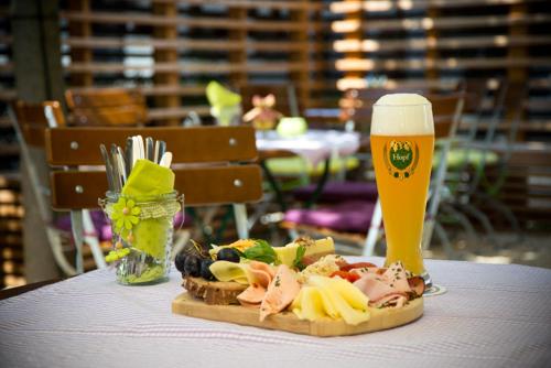 a plate of food and a glass of beer on a table at Hotel Gasthof Alter Wirt in Farchant