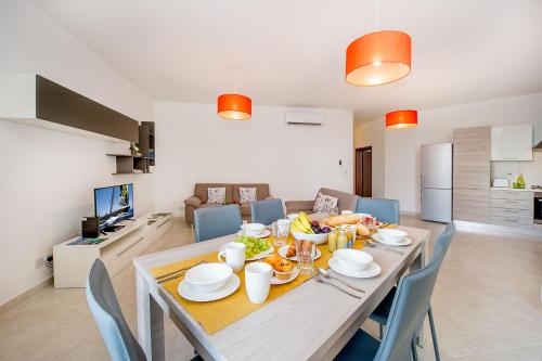 a dining room with a table with food on it at Hillock Residence Apartments in Marsalforn